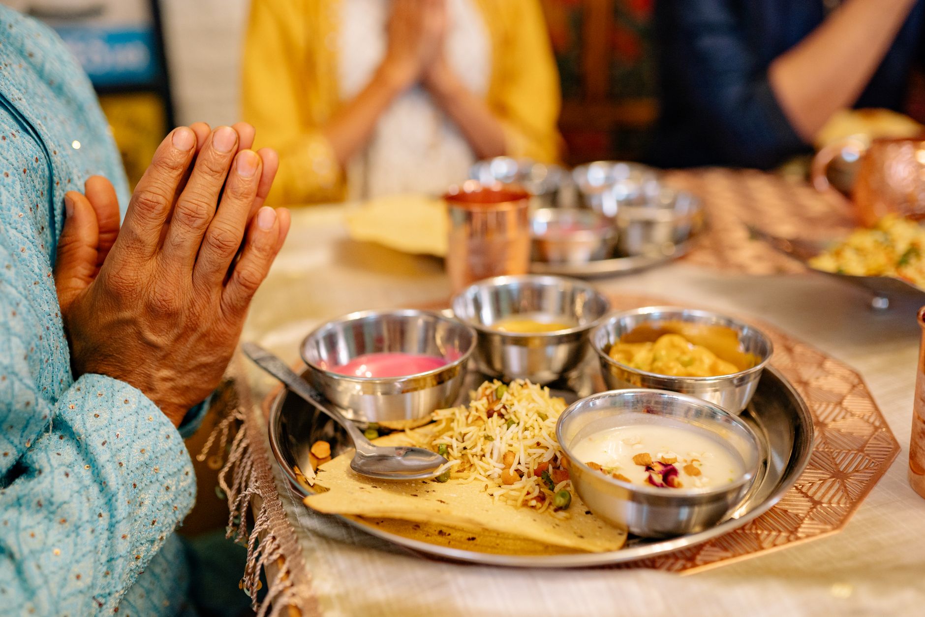 Colourful South Asian thali with dal, sabzi, rice, roti, raita + chutneys arranged on a banana leaf